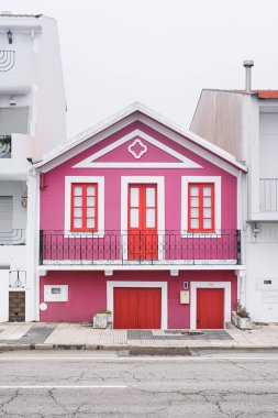 Aveiro, Portekiz - 24.10.2022: Palheiros adı verilen tipik renkli çizgili evler ile caddeye bakın. Costa Nova do Prado, Atlantik kıyısında Aveiro yakınlarında bir sahil köyü..