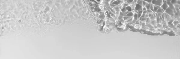 Light gray transparent clear calm water surface texture with splashes, waves and bubbles. Trendy abstract nature background. Water waves in sunlight. Long banner