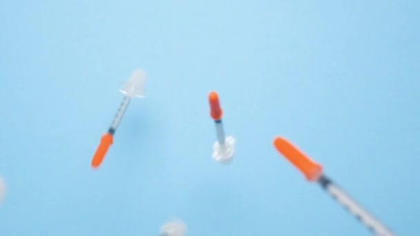 Aveiro ポルトガル 2022 青色の背景に落ちるプラスチックインシュリン注射器の雨 ワクチンとワクチンの概念 国際的な糖尿病意識の日 フルHdスローモーション医療ビデオ — ストック動画