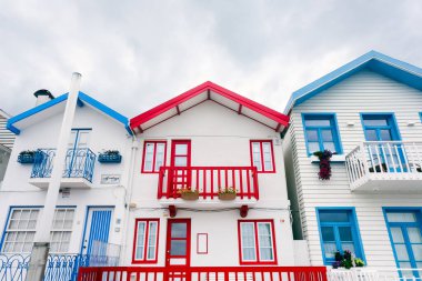 Aveiro, Portekiz - 24.10.2022: Palheiros adı verilen tipik renkli çizgili evler ile caddeye bakın. Costa Nova do Prado, Atlantik kıyısında Aveiro yakınlarında bir sahil köyü..