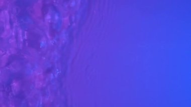 Neon Blue, pink and purple Water gradient texture with drops, splashes and waves. Organic water toned in blue and pink gradient with refraction of light slow motion video banner