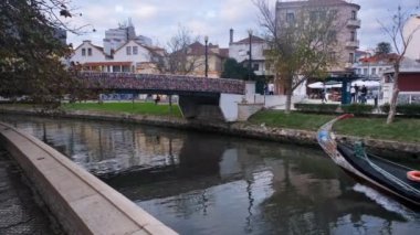 Aveiro, Portekiz - 14.11.2022: Aveiro Moliceiro turistik tur teknesi Ria de Aveiro kentsel su kanalını turistlerle birlikte geçiyor, Portekiz. Aveiro 'daki turist teknesiyle ilgili 4K çözünürlük videosu