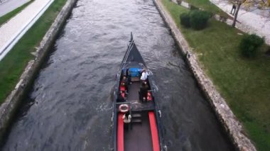 Aveiro, Portekiz - 02.12.2022: Portekiz 'deki Ria de Aveiro kentsel su kanalını turistlerle geçen Aveiro Moliceiro turistik tur teknesinin üst görüntüsü. Aveiro 'daki turist teknesiyle ilgili 4K çözünürlük videosu