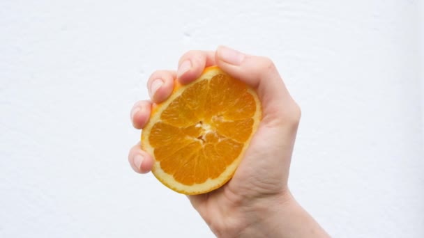 Hånd Klemmer Halvdelen Orange Orange Juice Flyder Isoleret Hvid Baggrund – Stock-video