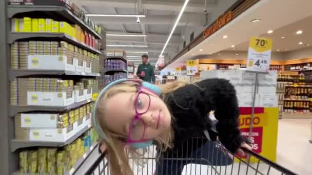 Estarreja ポルトガル 2023 家族の買い物中にスーパートロリーに乗る面白い小さな子供の女の子 スーパーで子供 フルHdビデオ — ストック動画