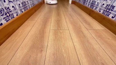 Robot vacuum cleaner cleaning floor. Working Automatic vacuum cleaner cleaning laminate. 4K resolution modern house cleaning equipment concept.