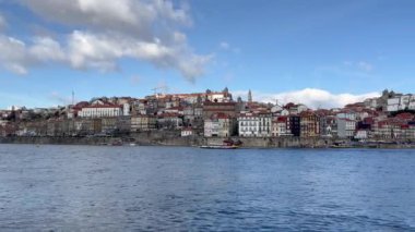 Porto, Portugal - 21.01.2023: Touristic view on the beautiful old town of Porto, river Douro and small bright boats full of tourists for excursion, Portugal travel video