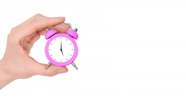 Hand holding beautiful small pink alarm clock with moving arrows isolated on white background. Concept of time. 4k resolution video banner with copy space.