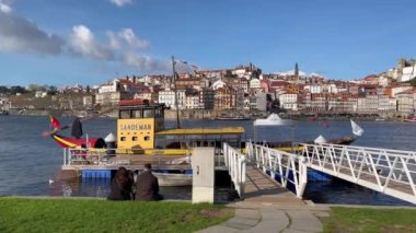 Porto, Portugal - 21.01.2023: Touristic view on the beautiful old town of Porto, river Douro and small bright boats full of tourists for excursion, Portugal travel video