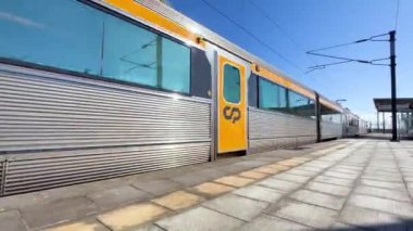 Estarreja, Portugal - 20.02.2023: A high-speed train passes by the station at high speed in Estarreja, Portugal. The train stops at the station and opens the doors