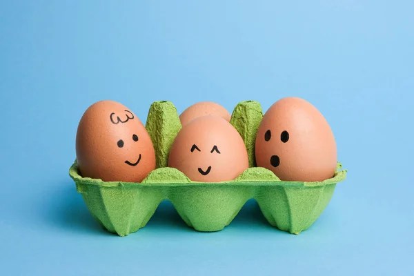 Χαριτωμένα Πασχαλινά Αυγά Αστεία Πρόσωπα Πράσινο Κουτί Απομονώνονται Γαλάζιο Φόντο — Φωτογραφία Αρχείου