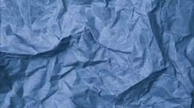 Kırışık kağıtların video üst görünümü. Mavi buruşmuş kağıt dokusu arka planı. Buruşuk, soyut kağıt arkaplan.