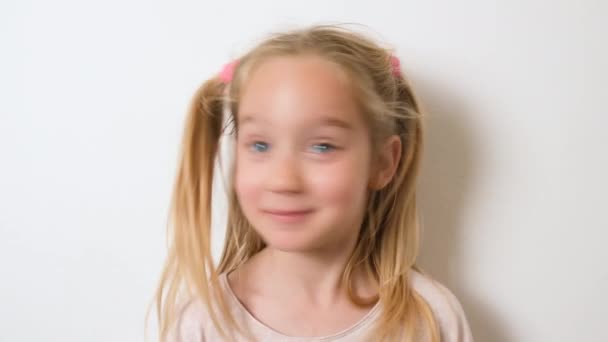 7年のかなり笑っている子供のブロンドの女の子は彼女の頭をうなずきません 彼の頭を負に振る ふける 笑顔と悲しみ — ストック動画