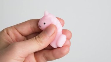 Hands are playing with anti-stress. Close up view on hands play with squash animals. The concept of relieving tension or stress in children and adults. 4K resolution video