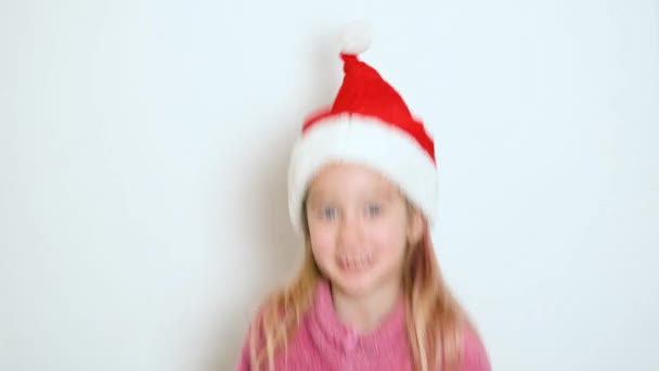 Mała Blondynka Czerwonym Kapeluszu Świętego Mikołaja Aktywnie Coś Mówi Patrzy — Wideo stockowe