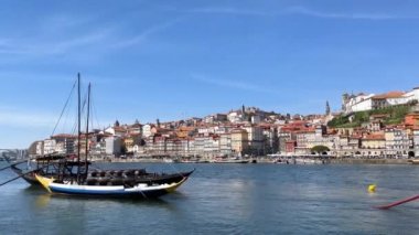 Porto, Portekiz - 20.03.2023: Porto, Douro nehri ve turist dolu küçük parlak tekneler üzerindeki turistik manzara, Portekiz seyahat videosu.