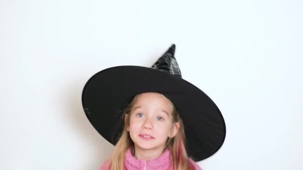 一个戴着黑女巫帽的金发小女孩正在积极地讲述一些事情 并看着摄像机 这个女孩唱或朗诵一首诗 视频肖像 4K分辨率视频 — 图库视频影像