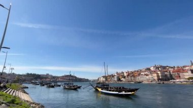 Porto, Portekiz - 20.03.2023: Porto, Douro nehri ve turist dolu küçük parlak tekneler üzerindeki güzel tarihi turistik manzara, Portekiz seyahat videosu.