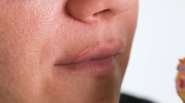 Bir kızın ya da kadının çörek yerken mutlu bir görüntüsü. Bir dişi donut yer. Fast food ve sağlıksız yemek. Tam HD yavaş çekim çözünürlük videosu.