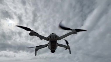 Gökyüzünün arka planında insansız hava aracı ya da helikopter. Dibe vurun. Yukarıdan fotoğraf ve video çekmek için modern teknolojiler. Kameralı bir kuadkopter..