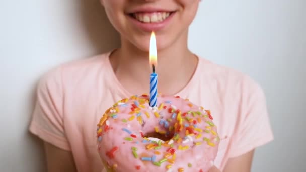 Uma Menina Feliz Sorrindo Adolescente Soprando Uma Vela Donut Rosa — Vídeo de Stock