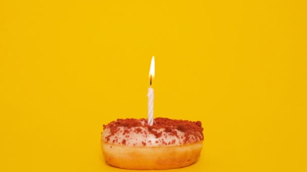 Ένα Όμορφο Ντόνατ Ένα Αναμμένο Κερί Απομονωμένο Κίτρινο Φόντο Ένα — Αρχείο Βίντεο