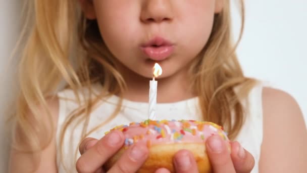 Uma Criança Menina Soprando Uma Vela Donut Rosa Feliz Aniversário — Vídeo de Stock