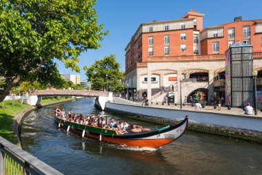Aveiro, Portekiz - 15.07.2023: Portekiz 'deki Ria de Aveiro kentsel su kanalını geçen Aveiro Moliceiro turistik tur teknesine bakın. Portekiz, Aveiro kanalında geleneksel tekneler.