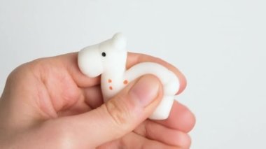 Hands are playing with anti-stress. Close up view on hands play with squash animals. The concept of relieving tension or stress in children and adults. 4K resolution video