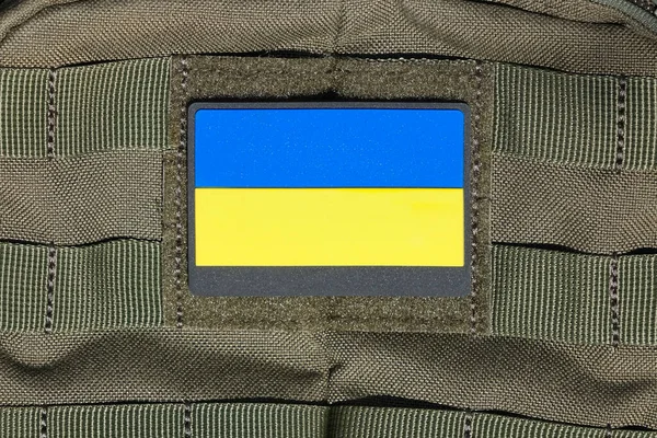 Patch on an adhesive tape with the Ukrainian flag on a military uniform, backpack, bag. Ukrainian flag attached to clothes or a bag with velcro.