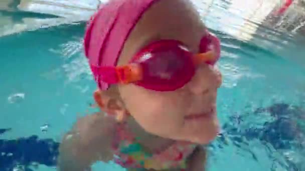 Een Kindermeisje Speelt Een Helder Sportpak Zwemvliezen Een Badmuts Een — Stockvideo