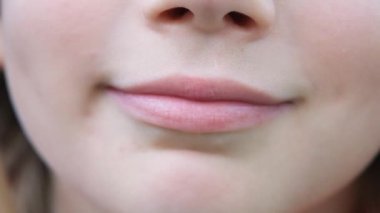 Kameraya bakıp gülen sarışın bir çocuğun video portresi. Yedi yıllık mutlu çocuk gülümsemesi. Childs gülümsüyor.