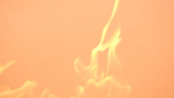 Flammes jaunes douces sur fond orange. Vidéo au ralenti du feu et des flammes. Flammes et étincelles brûlantes gros plan, motifs de feu.