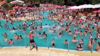 Amarante, Portekiz - 15.09.2023: İnsanlar havuzda ritmik müzik eşliğinde dans ediyorlar. Bir grup insan su parkında eğleniyor.