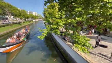 Aveiro, Portekiz - 15.07.2023: Portekiz 'deki Ria de Aveiro kentsel su kanalını geçen Aveiro Moliceiro turistik tur teknesine bakın. Portekiz, Aveiro kanalında geleneksel tekneler.
