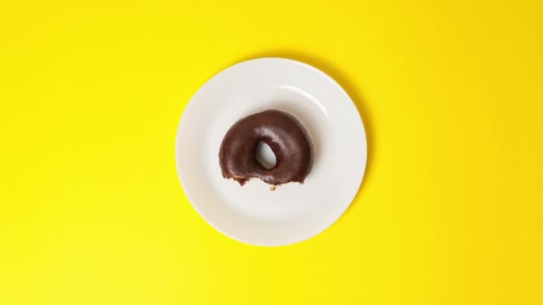 Comer Delicioso Donut Doce Coberto Com Esmalte Chocolate Fundo Amarelo — Vídeo de Stock