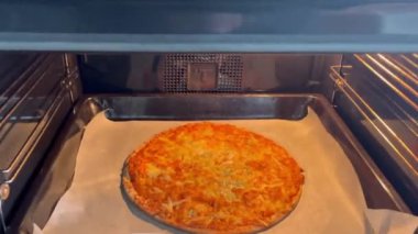 Ev yapımı pizza fırında. Fırında çözülmüş pizza pişirme manzarası. Fast food ya da konforlu gıda.