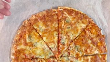 Hand 'in pizza kutusundan bir dilim pizza alırken yakın plan görüntüsü. Tek parça olmadan dört peynirli pizza. Kesik pizzanın üst görüntüsü. İtalyan yemeği, sokak yemeği, fast food, fast food