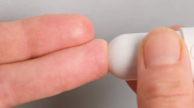 Kan şekeri seviyesini Glikoz ölçer 'e göre ölçmek için parmak üstüne mızrak kullanan kadını yakından izle. Sağlık ve Tıbbi Tedavi, Diyabet ve düşük veya yüksek glisemi konsepti.
