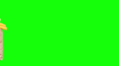 Yeşil ekranda yiyecek teslimatı ya da bağış konsepti videosu. Market alışverişi. Bir kız ya da kadın meyve, sebze, süt, yoğurt ve yumurta gibi yiyeceklerle dolu bir poşet tutuyor..