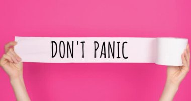 Ellerinde yumuşak, beyaz tuvalet kağıdı olan parlak pembe arkaplan üzerindeki videoyu kapat. Panik yapma. Hijyen konsepti. Beyaz tuvalet kağıdına panikleme.