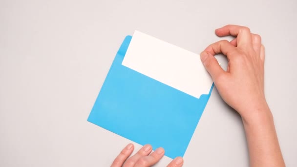 Ręka Wyciąga Białą Kartkę Jasnoniebieskiej Koperty Widok Góry Niebieskiej Koperty — Wideo stockowe