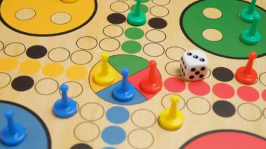 İnsanlar güzel tahta oyun tahtasında Ludo ya da Pachisi oyunu oynuyorlar. Ludo, iki ila dört kişilik bir strateji oyunudur. 4K çözünürlüklü aile oyunu video oyunu.