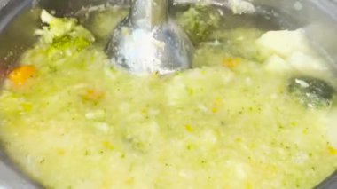 El çırpılmış çorbayı blender ile çırpma ve püre çorbası için sebzeleri püre haline getirme görüntüsü. Sağlıklı beslenme kavramı