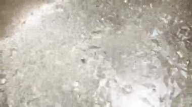 Çelik bir tencerede kaynayan suyun yakın görüntüsü. Hava kabarcıkları ve kaynayan su manzarası.