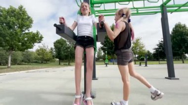 İki kız kardeş spor yapar. Sokakta yaz mevsimi ve çocuklar dışarıda spor salonunda oynuyorlar..