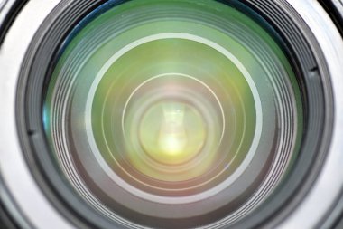 Büyüleyici, dairesel bir şekilde ışığı yansıtan bir kamera merceğinin yakın çekim görüntüsü. Teknoloji, fotoğrafçılık, film yapımı, optik ve yaratıcı medya projeleri için ideal.