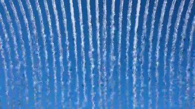 Su akıntılarının parlak mavi gökyüzüne karşı canlı görüntüsü, dinamik, soyut bir şablon yaratıyor doğa veya enerji temalı görseller için ideal.