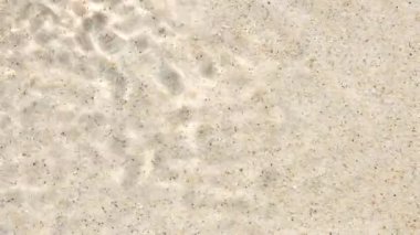 Su dalgalanması ve baloncuk kum üzerinde etkileşimi. Ayrıntılı sıçrama ışıkta örtüşen dalgalar yaratır. Doğal dokulara ve kıyı dinamiklerine net bir bakış