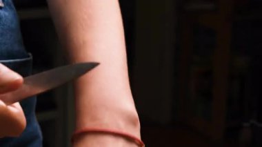 Küçük bir bıçakla sarı bir patatesi soyan kadın elleri. Sahne, yemek pişirme sürecinin hassasiyetini ve basitliğini sıcak bir mutfak ışığında yakalıyor.